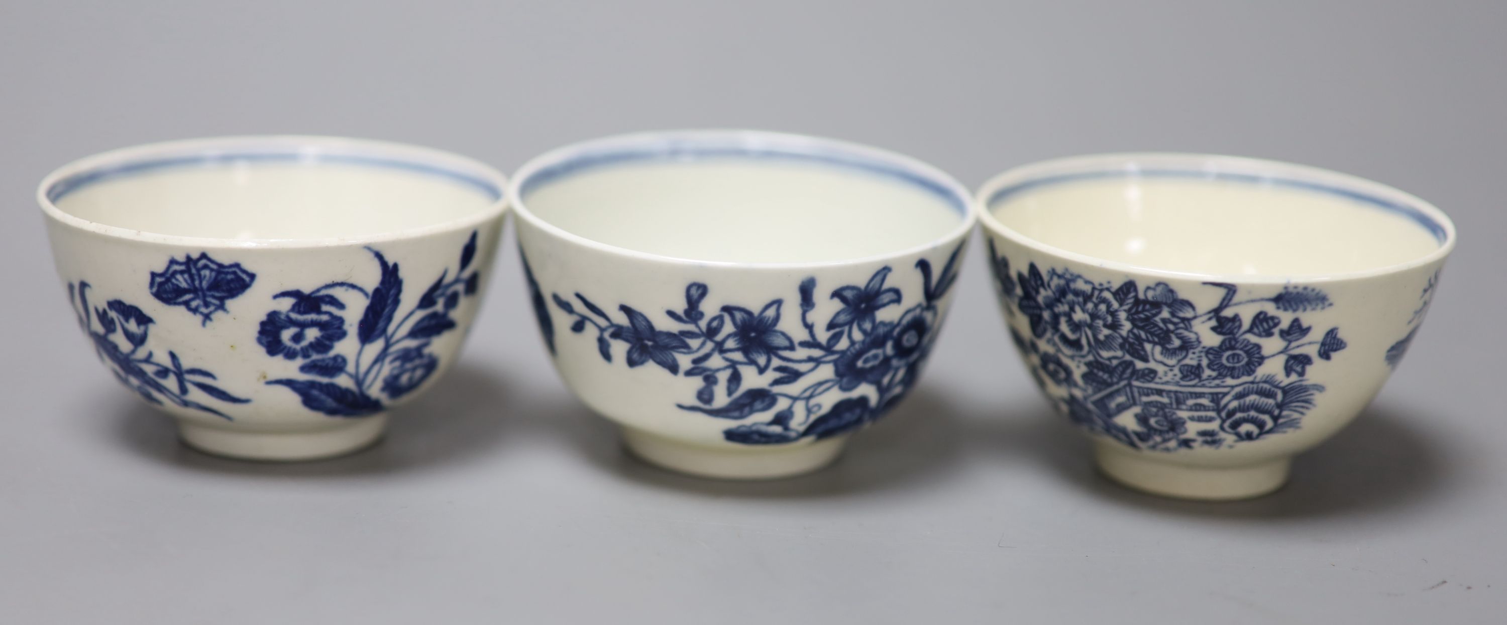 Three 18th century Worcester tea bowls and saucers, two printed with Three Flowers and one printed with the Fence pattern most with cre